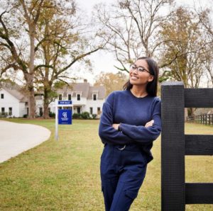 woman leaning on to a wooden fence